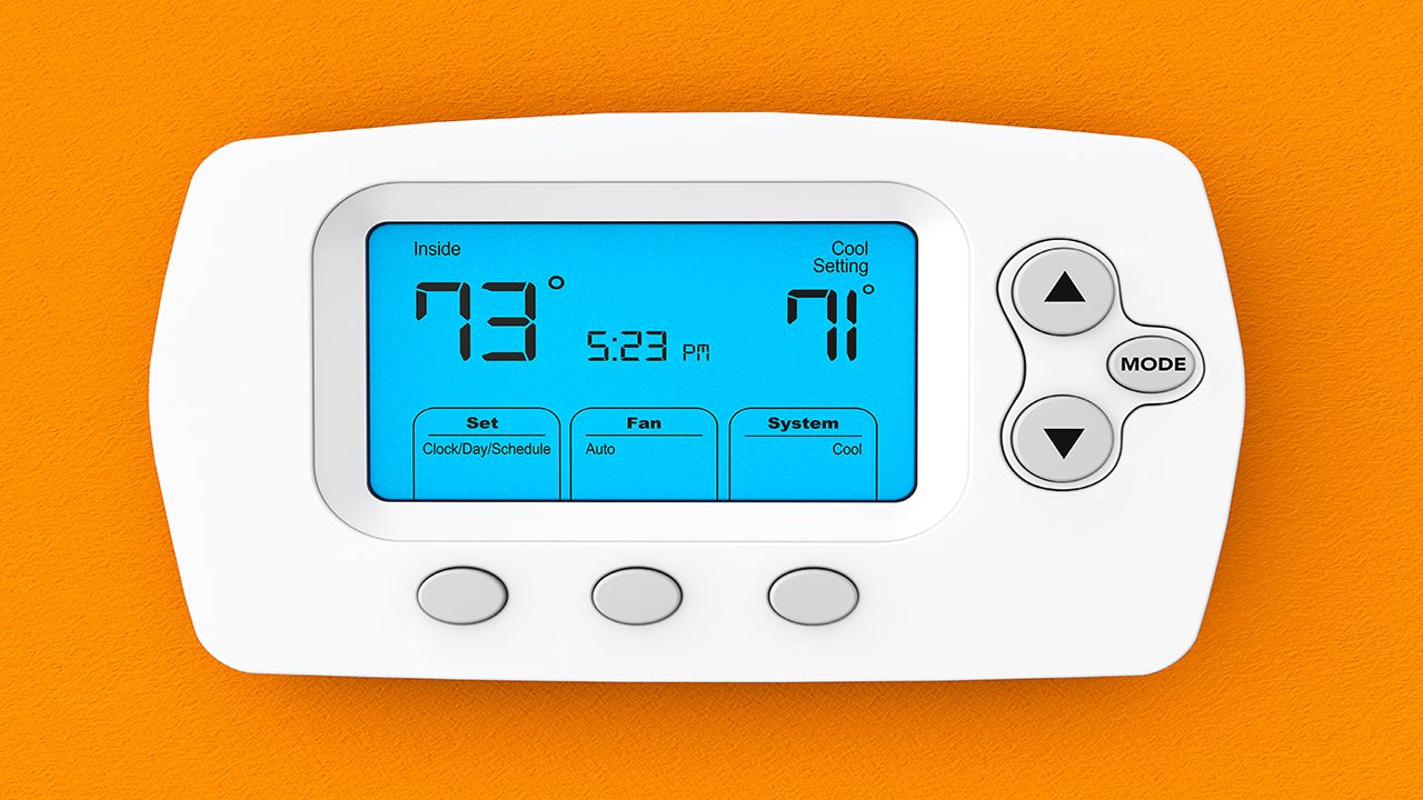 Modern Programming Thermostat on a orange wall